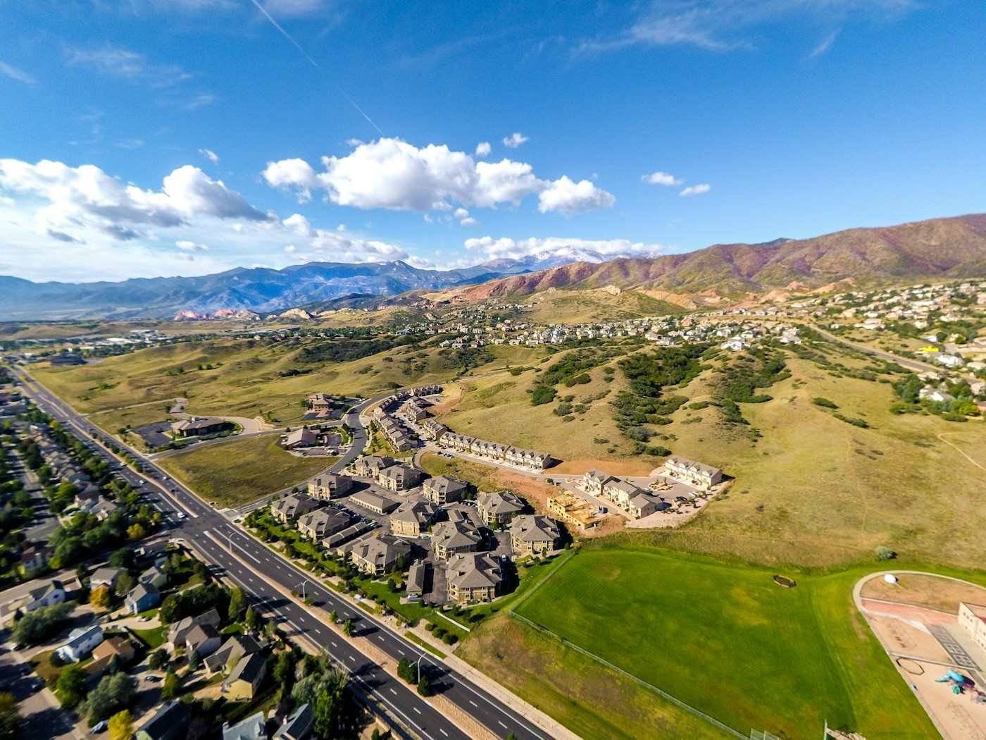 Aerial view of a new subdivision on rolling grassland below the foothills