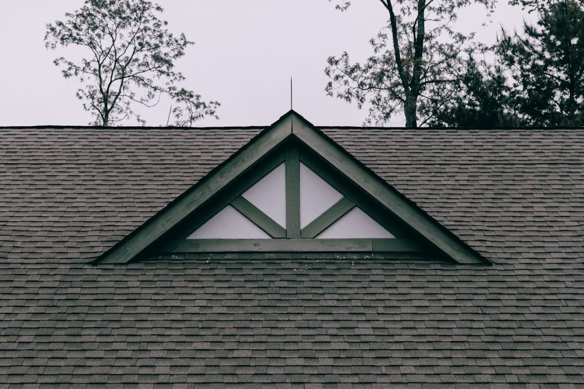 A dark architectural shingle roof with a small gable vent